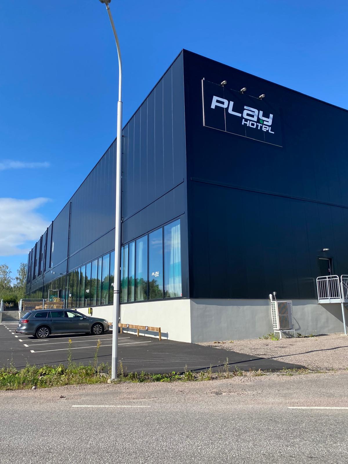 Play Hotel i Mjölby — exteriör med svart fasad och hotellets logotyp