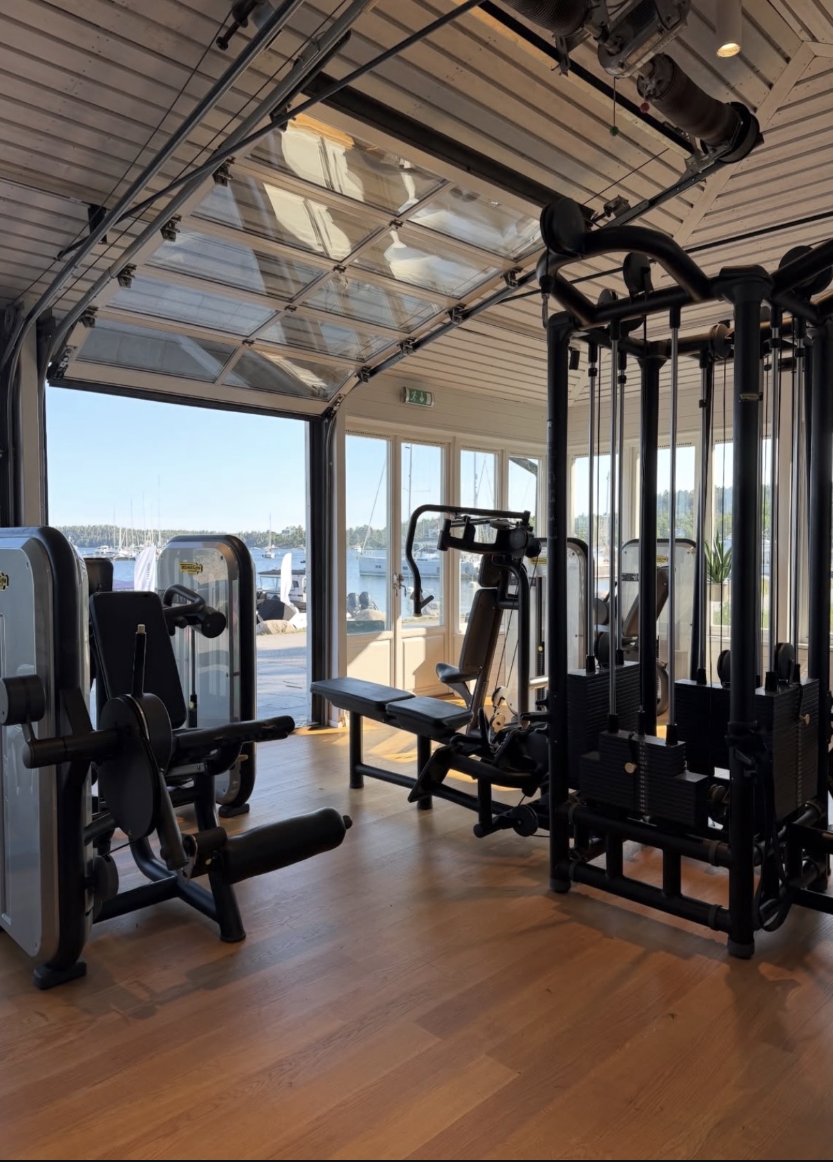 Hotellvikens Gym interiör med träningsmaskiner och utsikt över båthamn